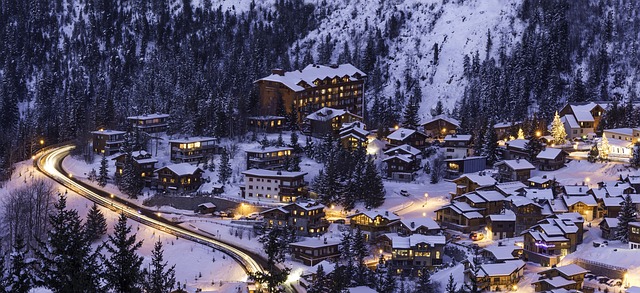 Une station de ski enneigée et ses installations touristiques toutes éclairées.