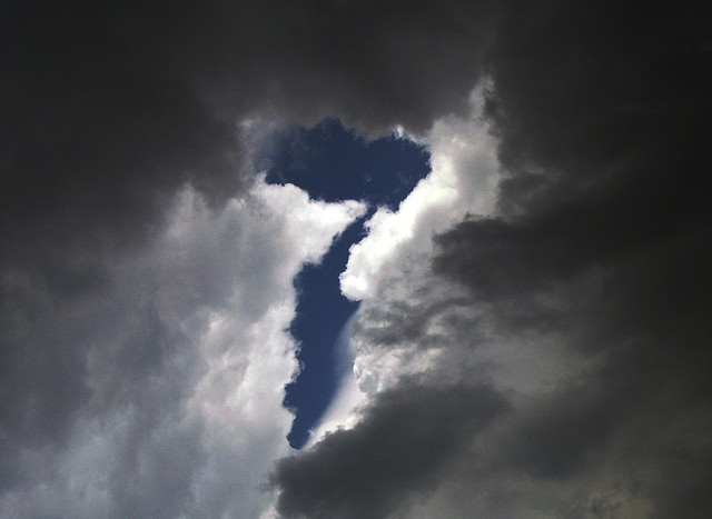 Un sept dessiné en creux par les nuages dans le ciel.