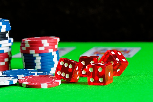 Des dés et des jetons de jeux, sur un tapis de table de casino.