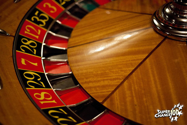 Photographie d'une roulette de casino avec des chiffres sur fond rouge et noir.