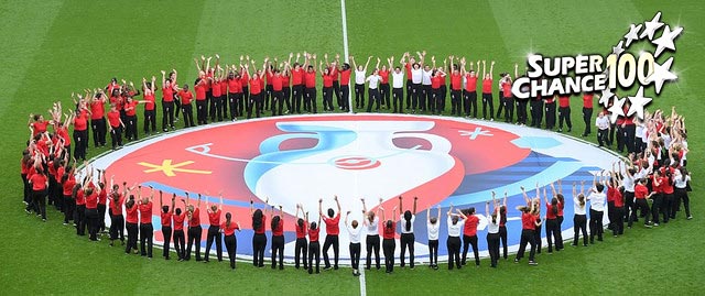 Photographie de personnes sur un terrain de foot en cercle autour du logo de l'Euro 2016.