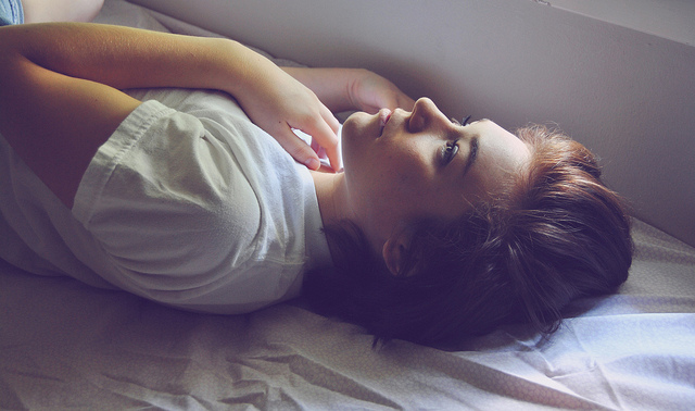 Photographie d'une femme éveillée dans son lit.