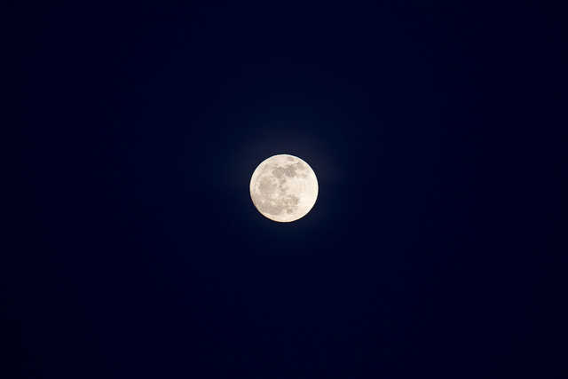 Photographie d'une pleine lune en pleine nuit.