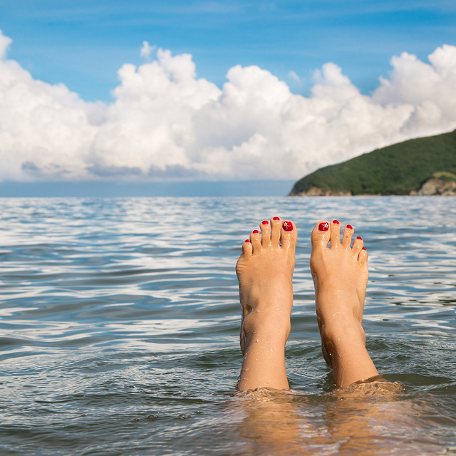 Des doigts de pieds en éventail à la plage.