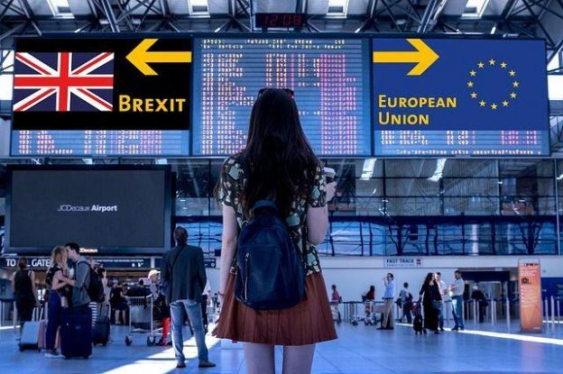 Jeune femme dans une gare avec le choix d'aller vers le Brexit ou l'Union européenne.