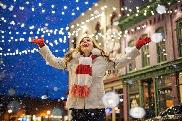 C'est une femme heureuse au milieu de décorations de Noel.